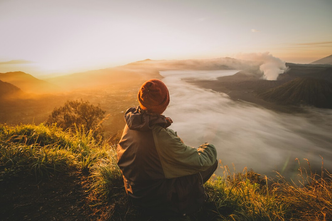 person meditating at sunrise