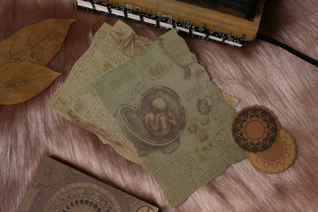 Open notebook with handwriting and a cup of coffee on a wooden desk